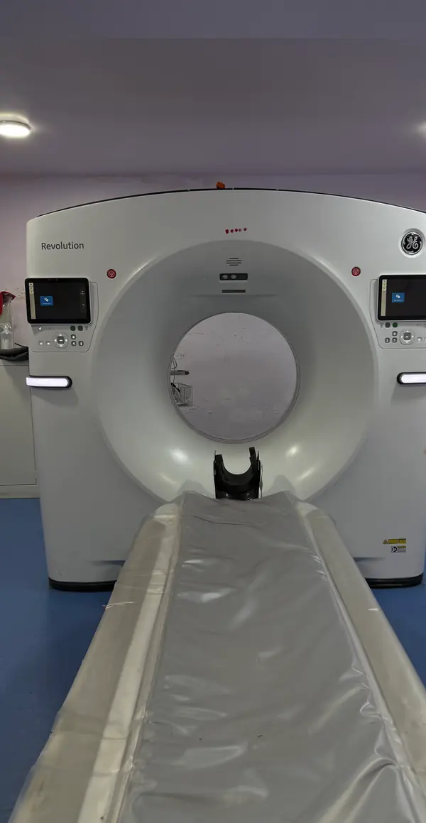 The CT scanner in the imaging room, seen head on with its patient couch extended.