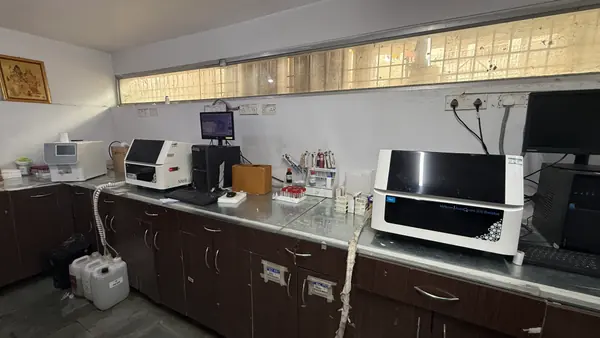 The biochemistry bench, with an automated analyser, a rack of blood sample tubes and the reporting terminal.